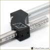 Black rectangular clamp with white engraved logo securing two silver metal rods on adjustable height dual bend short shifter
