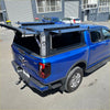 Blue ford ranger truck with black aluminium canopy and roof rack installed over the bed seen from the back side