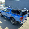 Blue ford ranger 2022 with aluminum canopy carport cover black hard tonneau and roof rack shown from back side