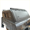 Gray metallic aluminum canopy carport cover with sleek angular design and roof rack for nissan navara double cab back view