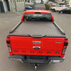 Red Ford Ranger XLT pickup truck showing the back with a black aluminium diamond-plate hard lid tonneau cover