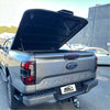 Gray ford ranger xlt pickup with black aluminium hard lid tonneau cover shown from the back side