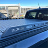 Black matte aluminum hard lid with textured diamond plate and embossed lite offroad branding for mazda bt-50 double cab