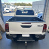 Back side of a white toyota hilux pickup truck showing black textured bedside rail covers 3 piece set 2015-2020