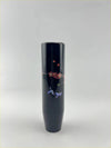 A sleek black glossy cylindrical blossom gear knob vase with delicate red and purple floral motifs