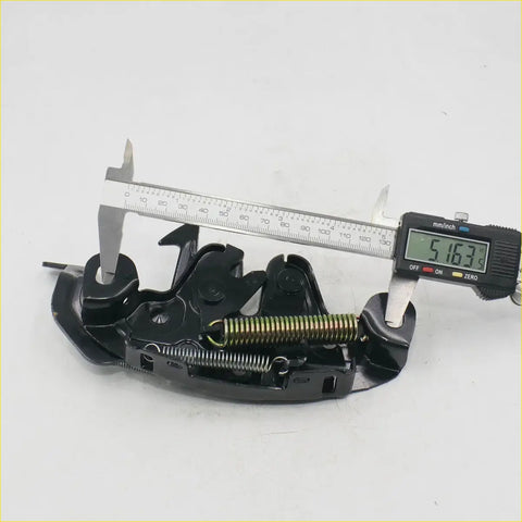 Black plastic bonnet latch striker with brass spring and metal parts for nissan navara d22 np300 shown from back side