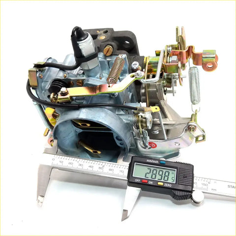 Gray metallic carburetor with brass and gold parts being measured by digital caliper for nissan datsun 720 z16 1982-1985