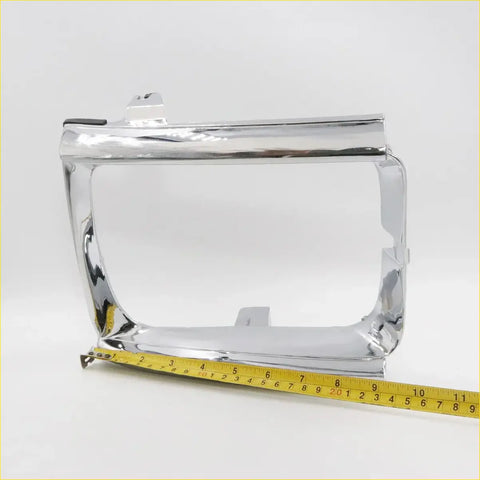Chrome head light door for Toyota Hilux 1988-1997 with a sleek polished chrome rectangular metal dashboard frame and mounting brackets
