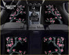 Black car floor mats with a detailed pink cherry blossom tree design on a dark background for custom fit