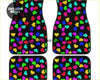 Set of four black car floor mats with vibrant multicolored rainbow heart pattern for custom style and protection