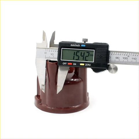 A glossy maroon plastic distributor cap for datsun nissan 620 j13 j15 1972-1979 being measured with digital caliper