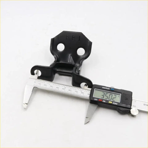 Black plastic door hinge for Toyota Hilux 1978-1983 with two circular holes and central hinge mechanism