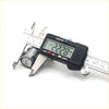 A black digital caliper with a silver metal body measuring a door lock cylinder for toyota hilux 1988-1997