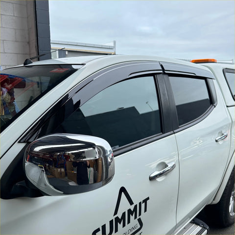 Black plastic door visors window monsoons weather shields installed on white mitsubishi triton pickup truck
