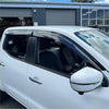 Black plastic door visors window monsoons weather shields installed on a white nissan navara np300 vehicle