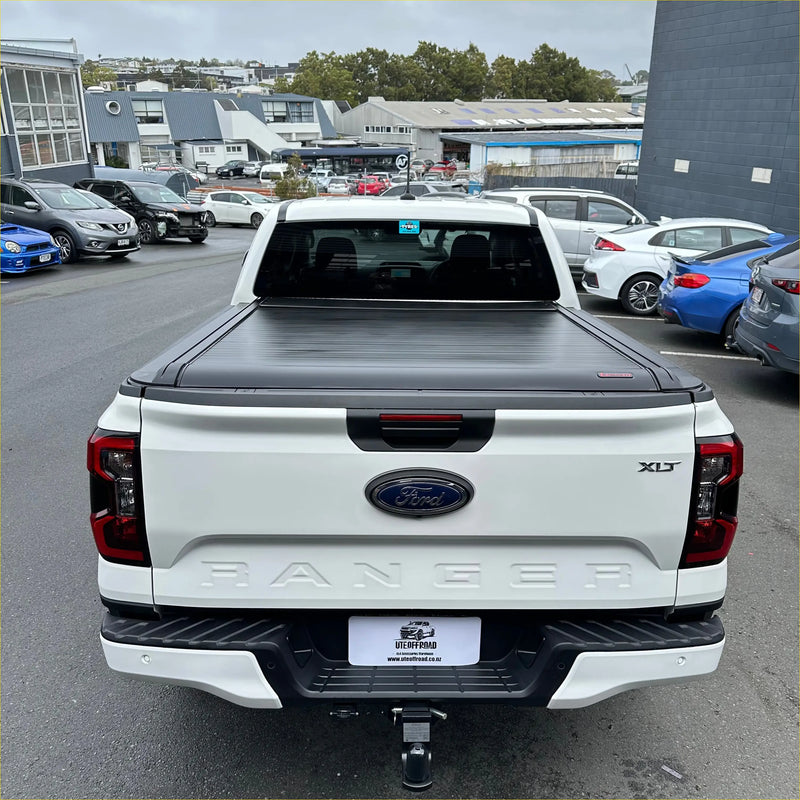 White ford ranger xlt pickup truck backside with black electric roller shutter tonneau cover for 2022+ new ranger