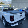 White ford ranger pickup truck with black electric roller shutter tonneau cover on the back side bed