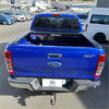 Vibrant blue ford ranger xlt with black electric roller shutter tonneau cover and chrome accents back view