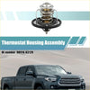 Silver and black engine coolant thermostat housing for Toyota Tacoma with a visible spring mechanism on the backside