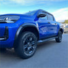 Vibrant blue toyota hilux with matte black 4-inch fender flares and black alloy wheels for rugged off-road use