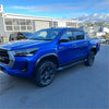 Vibrant blue toyota hilux with 4 inch matte black fender flares black alloy wheels and side steps 2021-2024 model