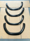 Black glossy finished plastic fender flares 4 inch style for 2021 2024 toyota hilux sr sr5 matte black arranged on cardboard