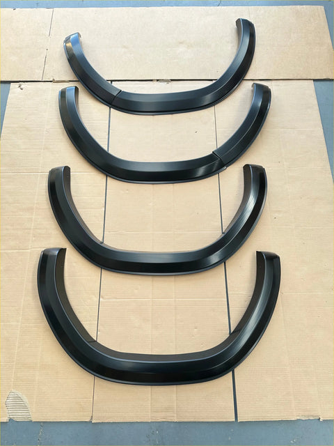 Black glossy finished plastic fender flares 4 inch style for 2021 2024 toyota hilux sr sr5 matte black arranged on cardboard
