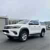 White toyota hilux 2015-2017 with lychee texture bolt style fender flare and black side steps viewed from the back
