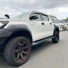 White Toyota Hilux Rocco 2018-2020 with black lychee texture bolt-on fender flares side steps and wheels