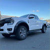 White ford ranger raptor with matte black sport smooth style fender flares and silver alloy wheels in front view