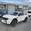 White ford ranger px1 2012-2015 with black fender flares and rugged tires showing the back side of the truck
