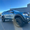 Dark blue metallic ford ranger with black lychee texture bolt style fender flares and rugged off-road tires