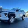 White mitsubishi triton 2019-2023 with matte black bolt style fender flares and roof rack seen from the side