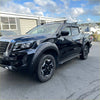 Black nissan navara pickup with matte black bolt style fender flare black alloy wheels and roof rack