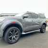 Gray metallic nissan navara np300 pickup with black alloys and roof rack featuring oem style red layer fender flares