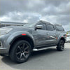 Gray metallic nissan navara pickup with black alloy wheels and roof rack featuring red layer oem style fender flare