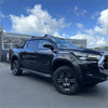 Black toyota hilux 2021-2024 with bolt style matte black fender flares and glossy black alloy wheels visible from front angle