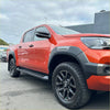 Vibrant orange Toyota Hilux 2021-2024 SR5 Cruiser with grey OEM style fender flares and rugged off-road tires