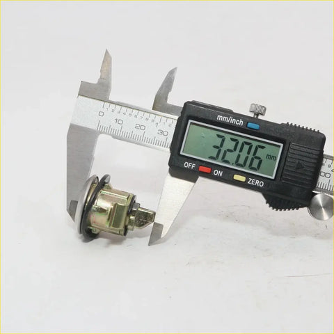 A metallic cylindrical fuel lid gas lock with brass body and black gasket for nissan pathfinder 720 sd23 d23 ute truck