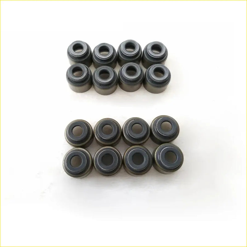 Set of 16 black valve stem oil seals for toyota hiace hilux 2trfe arranged in two rows on white surface