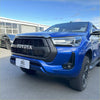Vibrant blue toyota hilux 2021-2024 sr sr5 with black honeycomb grille and sleek led headlights visible from front