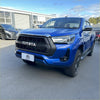 Vibrant blue toyota hilux 2021-2024 sr sr5 with black grille and rugged off-road tires shown from front side