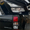 Black colorado pickup truck showing matte headlight covers with sleek led headlights and bold red taillight covers back side