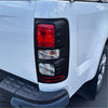 Black plastic taillight cover with red clear and amber lenses installed on white holden colorado 2016-2020 truck