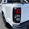 Black rectangular taillight cover with red amber and clear lenses on white holden colorado 2016-2020 rear fender