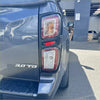 Back side view of dark gray metallic isuzu d-max 2021-2023 pickup truck with sleek modern red and clear taillight covers