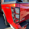 Red isuzu d-max pickup with glossy finish and black trim shown with matte black headlight and taillight covers