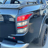 Black glossy mitsubishi triton pickup truck back with red accent taillight covers and textured bed liner 2015-2018