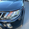 Black nissan suv with sleek glossy paint and chrome grille shown with headlight and taillight covers for mitsubishi triton 2015-2018