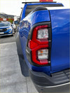 Back view of vibrant blue ford ranger with bold red taillight and 4x4 badge featuring headlight and taillight covers for toyota hilux 2021-2025 sr5